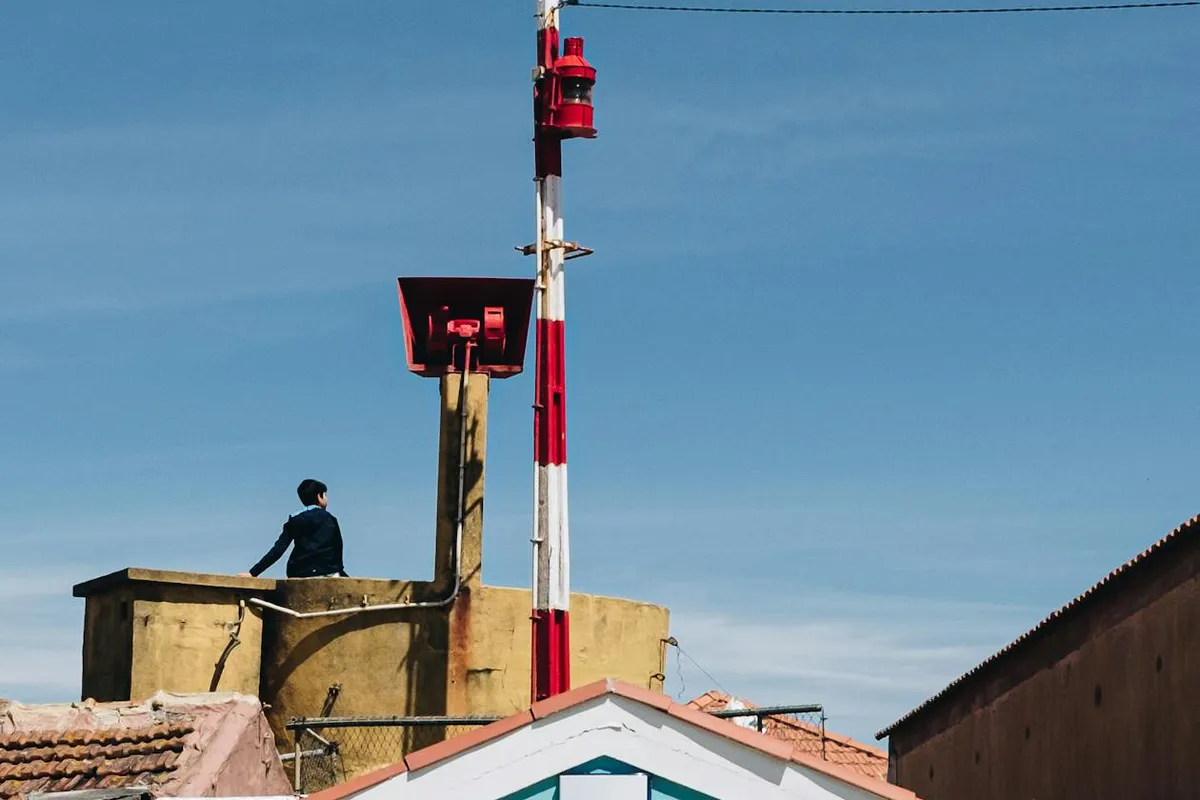 Insurance adjuster on roof examining shingle damage with clipboard and documentation
