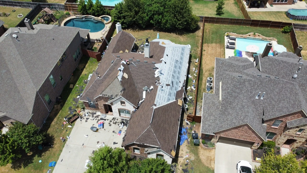 Team of professional roofers efficiently working on new roof installation on a sunny day